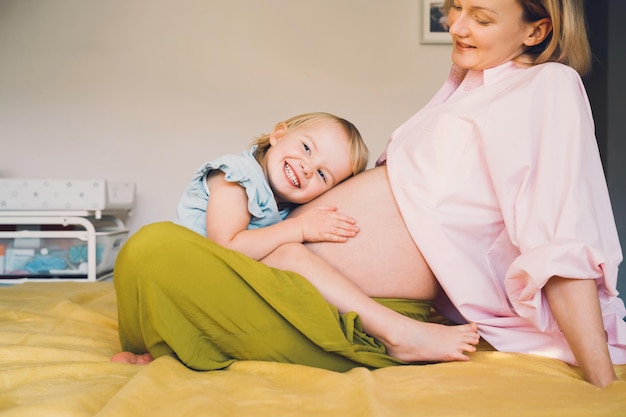 Foto schwangere mutter und tochter zusammen zu hause frau mit ihrem ersten kind während der zweiten schwangerschaft