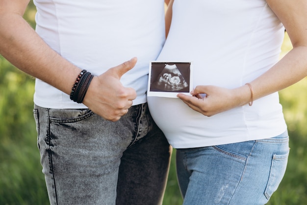 Schwangere Paare, die Ultraschallscan halten. Konzept des Schwangerschaftsgesundheitswesens.