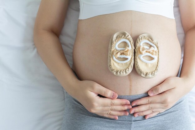 Foto schwangerschaft liebevolles konzept junge schwangere und ihre babyschuhe