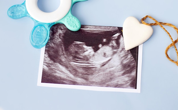 schwangerschafts- und babywartekonzept ultraschallbild mit fötus in der gebärmutter und einem weißen keramikhörgerät