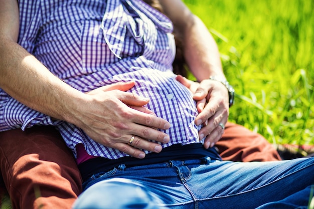 Schwangerschaftshände, die schwangeren Bauch umarmen