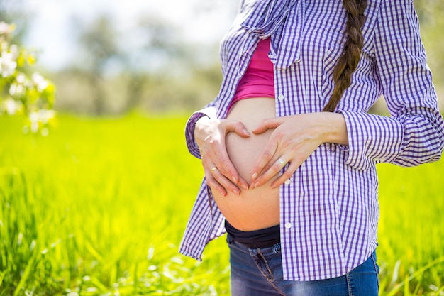 Schwangerschaftshände, die schwangeren Bauch umarmen