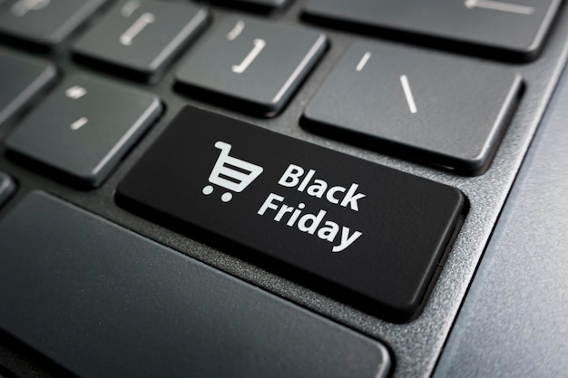 Schwarz-Freitag-Text und Einkaufswagen auf der Tastatur Schwarz-Freitag-Konzept schwarzer Knopf auf der Tastatur eines modernen Ultrabooks Überschrift auf dem Knopf
