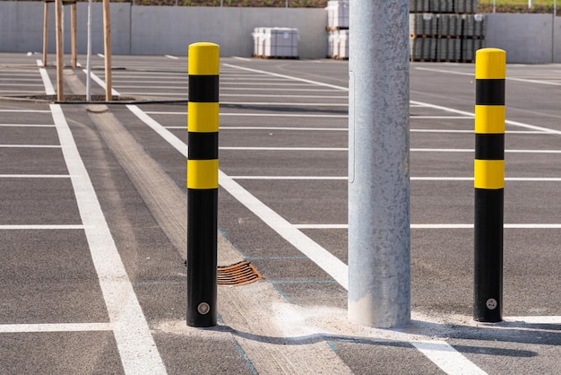 Schwarz-gelbe Poller auf dem großen Parkplatz