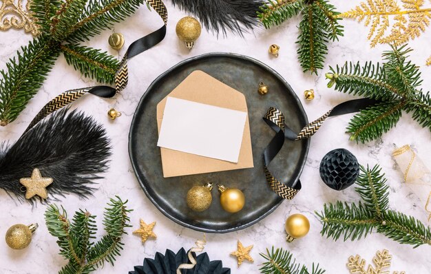 Schwarz-goldene Weihnachtstischdekoration mit Kartenornamenten und Tannenzweigen Mockup