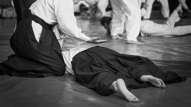 Schwarz-Weiß-Bild von Aikido Athletenmädchen, die an der Kampfkunst des Aikido beteiligt sind Die traditionelle Form der Kleidung im Aikido