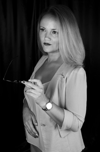 Schwarz-Weiß-Porträt einer eleganten Geschäftsfrau im Studio, die in einem Business-Anzug steht