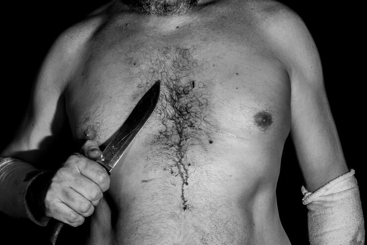 Foto schwarz-weiß-porträt eines hemdlosen mannes, der ein messer auf seine brust richtet