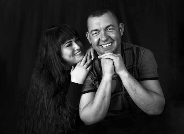 Schwarz-Weiß-Porträt eines verliebten Paares im Studio, wenn eine Frau einen Mann ansieht