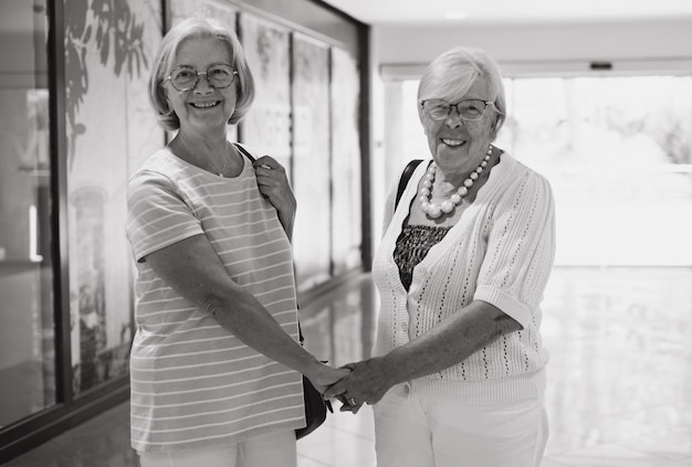 Foto schwarz-weiß-porträt zweier weißhaariger seniorinnen, die gerne einkaufen