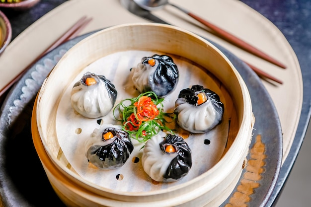 Schwarz-weiße vegetarische Dimsums in einem Holzdampfer