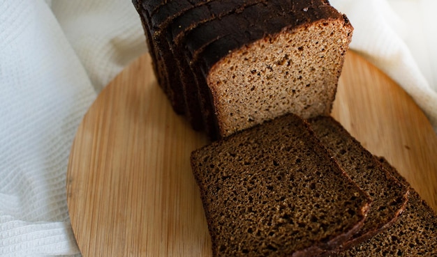 Schwarzbrot liegt auf einem runden Holzschneidebrett