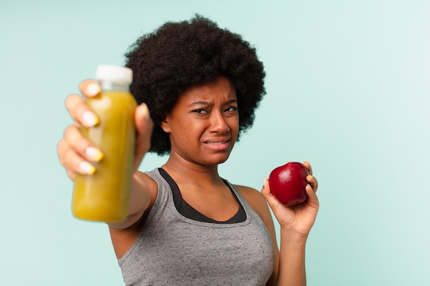 Schwarze Afro-Fitness-Frau mit Smoothy