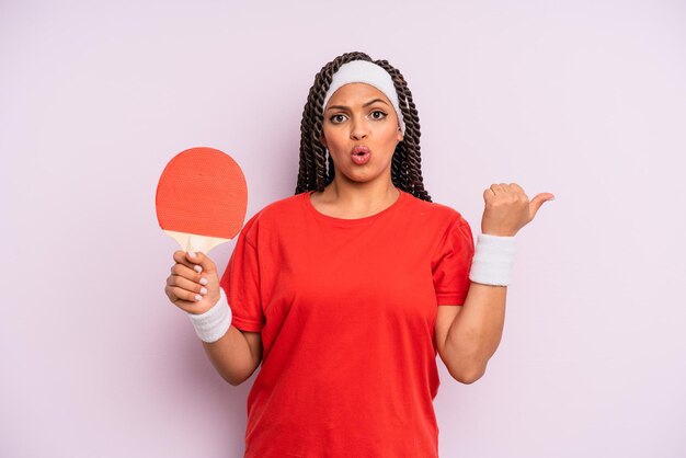 Schwarze Afro-Frau, die erstaunt ungläubig aussieht. Ping-Pong-Konzept