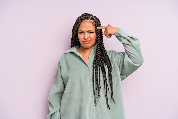 Foto schwarze afro-frau, die sich verwirrt und verwirrt fühlt und zeigt, dass sie verrückt oder verrückt sind