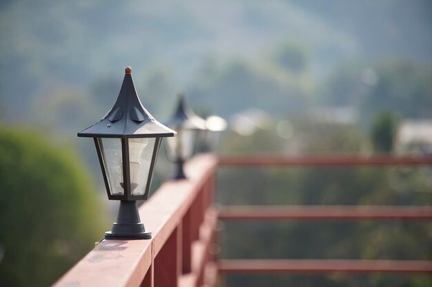 Schwarze antike Lichtsonde auf einem roten Metallzaun