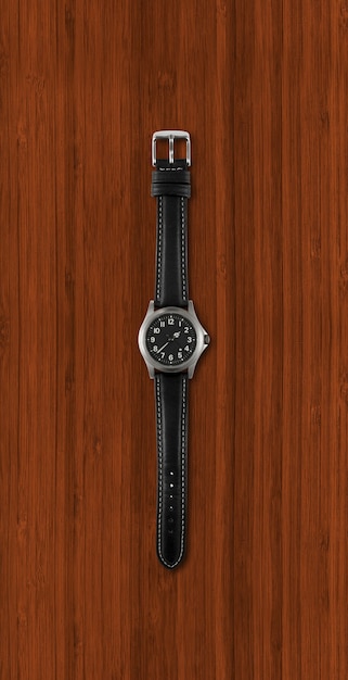 Schwarze Armbanduhr lokalisiert auf dunklem hölzernem Hintergrund