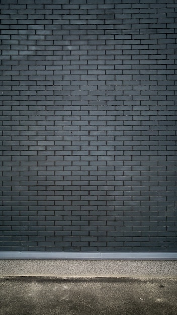 schwarze Backsteinmauer und Betonboden