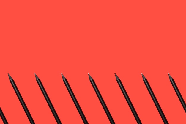 Schwarze Bleistifte auf einem geometrischen Muster des roten Hintergrundes