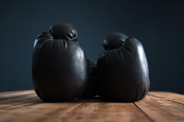 Schwarze Boxhandschuhe auf Holztisch