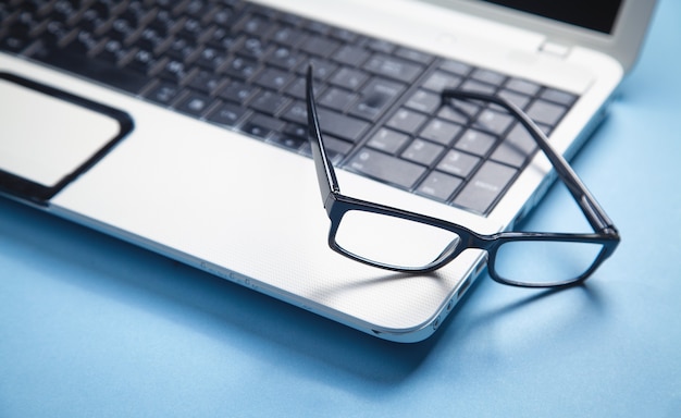 Schwarze Brille auf der Laptoptastatur.