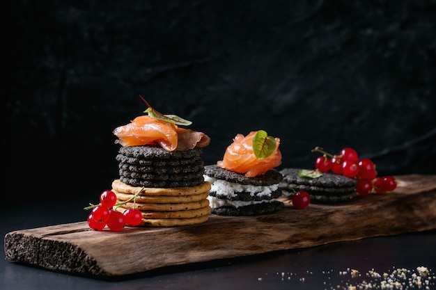 Schwarze Cracker mit Lachs und Beeren