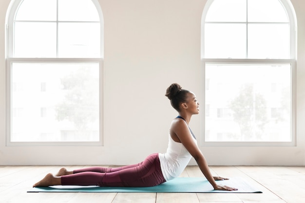 Schwarze Dame macht eine Bhujangasana-Pose