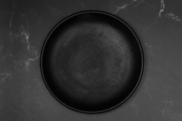 Schwarze flache Platte auf einer Küchentheke aus schwarzem Marmor in einer Draufsicht