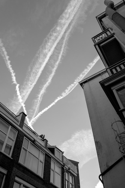 Foto schwarze fotografie himmel und häuser mit dächern und spuren von jets oder flugzeugen niederlande den haag