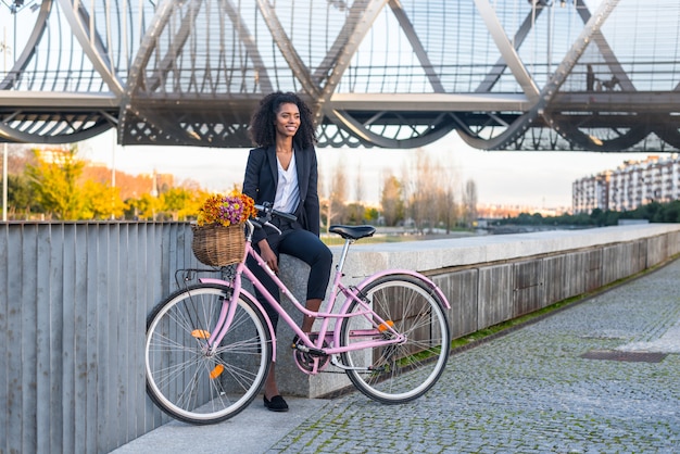 Schwarze Frau des Geschäfts mit Weinlesefahrrad