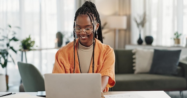 Schwarze Frau, die im Home-Office und Laptop für Forschung in der Fernarbeit soziale Medien oder Blog in der Wohnung schreibt Freelance-Mädchen am Schreibtisch mit Computer E-Mail-Website-Post und Online-Chat im Haus