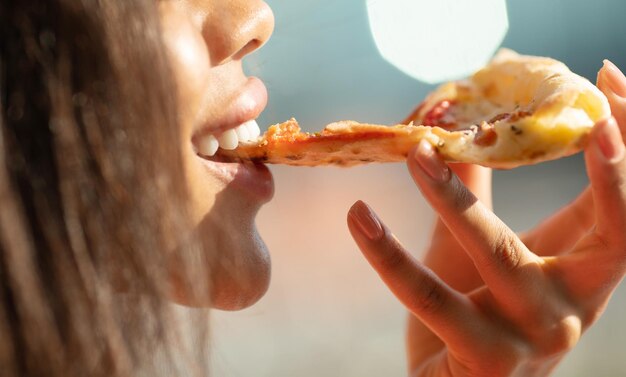 Schwarze Frau Hand nimmt ein Stück Fleisch Pizza Junge Frau, die Pizza im Freien in der Straße isst