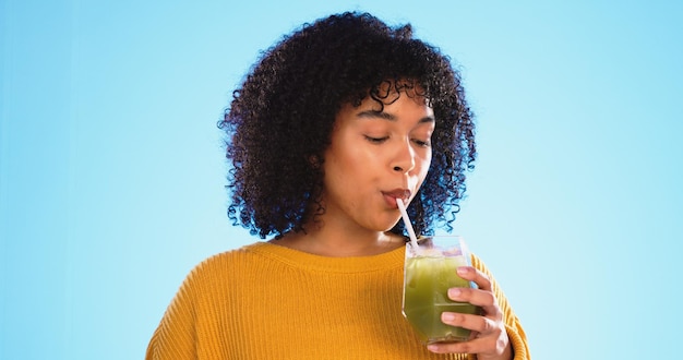 Schwarze Frau mit grünem Saft trinkt und gesunder Smoothie einer Person mit Gewichtsverlustgetränk Studioblauer Hintergrund und Frau mit pflanzlicher Ernährung und Detox-Fruchtshake für Gesundheit und Wohlbefinden