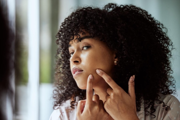 Schwarze Frau Spiegel- und Gesichtspickelreinigung für Schönheitshygiene Hautpflege Wellness und Kosmetik Dermatologie im Badezimmer Junges afrikanisches Mädchen, das Gesichtsakne und Hände auf Selbstpflegekosmetik überprüft
