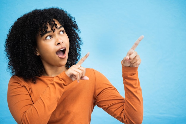 Schwarze Frau Überraschung und zeigende Hände im Studio für Nachrichtenankündigung Klatschbenachrichtigung und blauer Hintergrund Afrikanisches gen z Mädchen junges weibliches Modell und Mode für wow Handzeichen und Glück