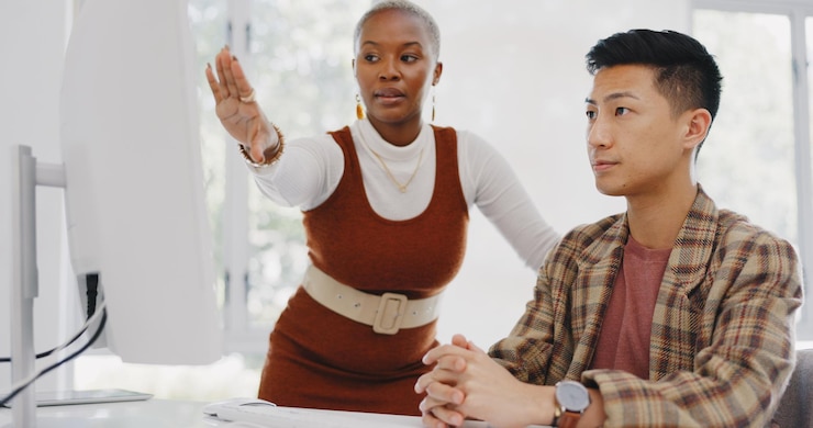 Foto schwarze führungsfrau oder managerin, die einen mitarbeiter in bezug auf digitale seo-marketingstrategie oder feedback betreut computerberichtsunterlagen oder coaching von werbeexperten, die japanischen arbeitern helfen oder sie schulen