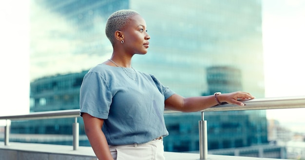 Schwarze Geschäftsfrau in der Stadt auf dem Balkon und denkt über Chancen, Visionen und professionelle Denkweise nach. Weibliche Führungskraft, CEO und Managerin mit Fähigkeiten und Motivation für Karriereziele als zukünftige Führungskraft
