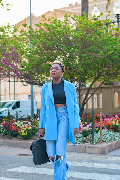 Schwarze Geschäftsfrau mit blauem Anzug überquert die Straße