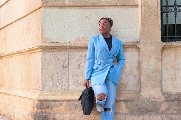 Schwarze Geschäftsfrau posiert im blauen Anzug auf der Straße