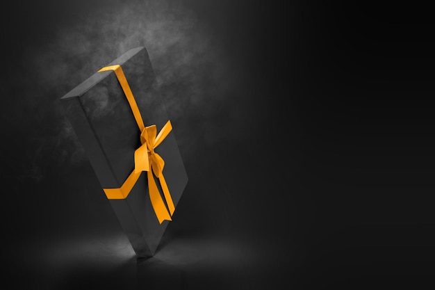 Schwarze Geschenkboxkappe mit goldenem Band auf schwarzem Hintergrund. Black Friday-Konzept
