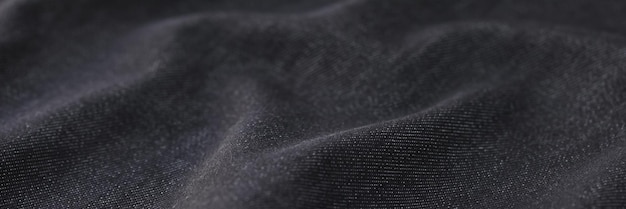 Schwarze Grunge-Stoffstruktur für abstraktes Hintergrundmaterial für Kleidungsdekorationskonzept
