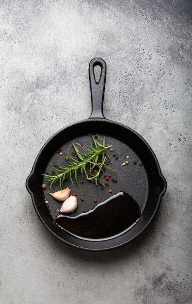 Schwarze Gusseisenpfanne mit Rosmarin-Knoblauch-Pfefferöl