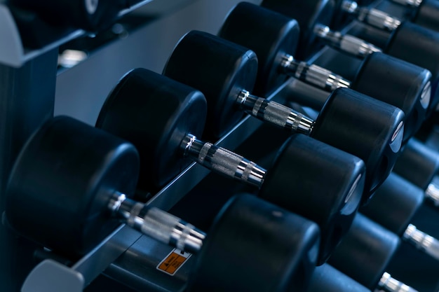 Schwarze Hanteln im Fitnessstudio. Sportausrüstung. Viele Metallhanteln auf der Theke im Sportfitnesscenter.