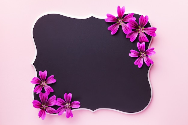 Schwarze hölzerne Tafel mit purpurroten Blumen