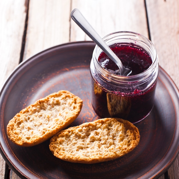 Schwarze Johannisbeere Marmelade im Glas und Cracker