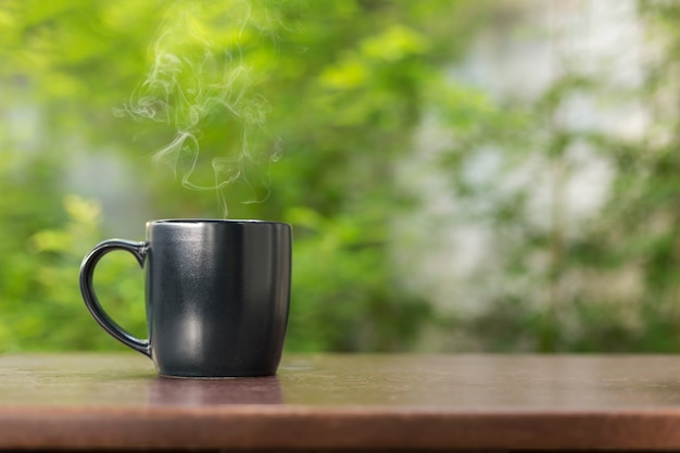 Schwarze Kaffeetasse auf Holztisch