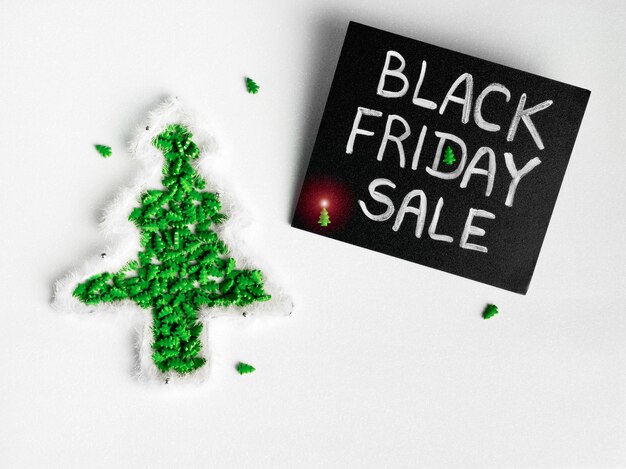 Schwarze kreidetafel mit kreideschriftzug black friday sale auf weißem glitzer