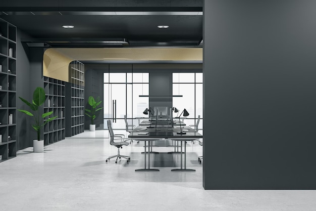 Schwarze leere Wand mit Platz für Bildrahmen in minimalistischem Innenbüro mit dunklen Wänden Arbeitsbereiche mit modernen Computern auf Betonboden und grünen Pflanzen im Blumentopf 3D-Rendering-Mockup