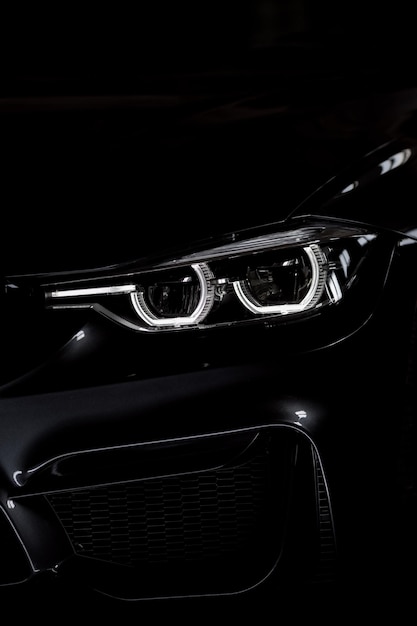 Schwarze moderne Auto-Scheinwerfer Frontansicht Silhouette eines schwarzen Sportwagens mit Scheinwerfern aus der Nähe