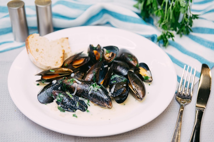 Foto schwarze muscheln in weißweinsauce gekocht und mit frischer petersilie bestreut
